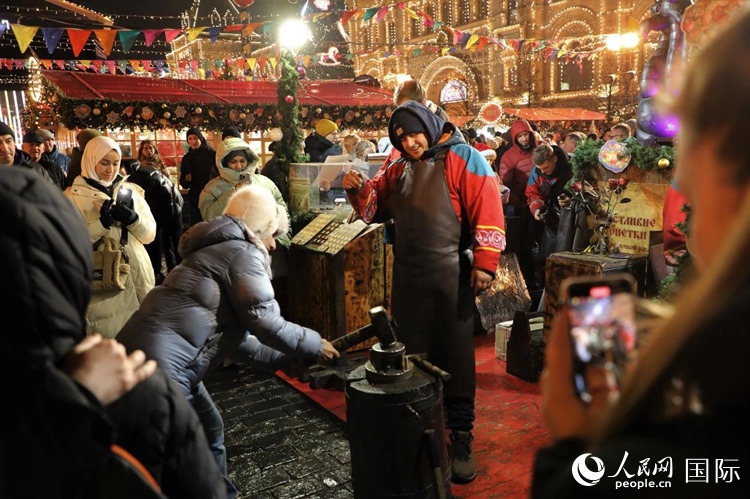 游客在新年集市上體驗(yàn)制作紀(jì)念幣。人民網(wǎng)記者 隋鑫攝