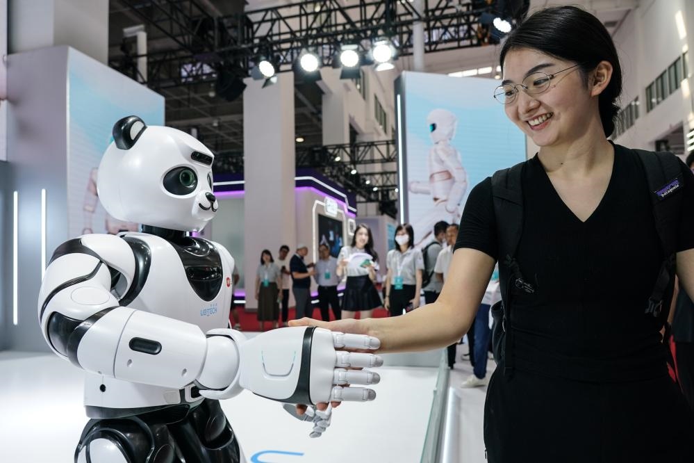 2023年8月16日，一名女士在北京舉辦的2023世界機器人大會現(xiàn)場與智能機器人握手。新華社記者彭子洋攝