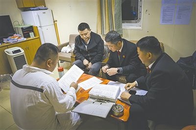 圖②：法官向船長講解相關(guān)法律規(guī)定，查看船舶資料，并與船方辦理扣押船舶的手續(xù)。