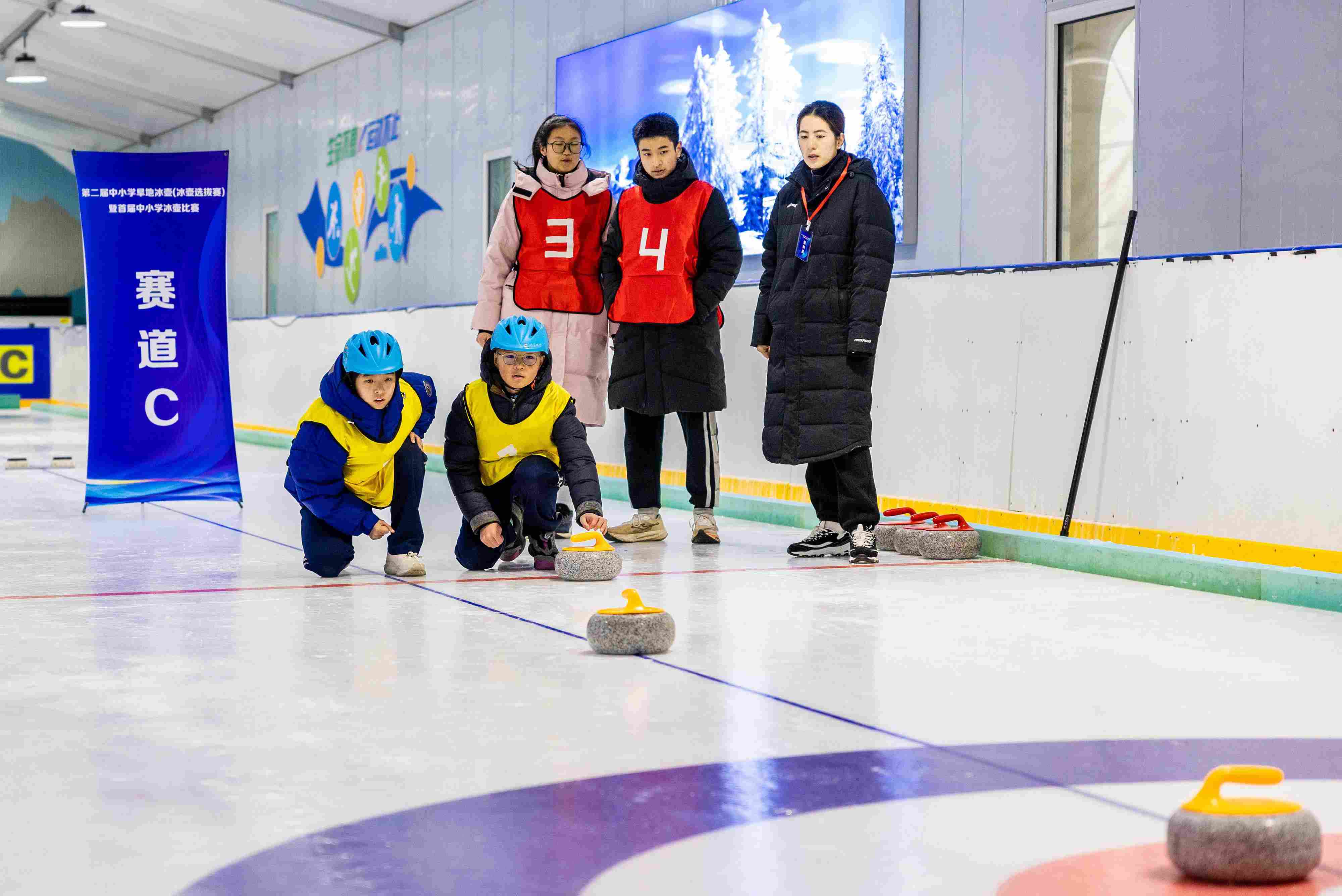 2023年12月10日，參賽選手在呼和浩特首屆中小學(xué)冰壺比賽中投擲冰壺。