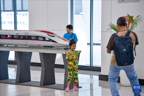 1月24日，在印度尼西亞雅加達(dá)哈利姆站候車大廳，一名小朋友和雅萬高鐵高速動車組模型合影。新華社記者 徐欽 攝