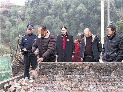  圖③：庭審結(jié)束后，在法官的見證下，陳某在院壩邊重新開鑿一條通道。