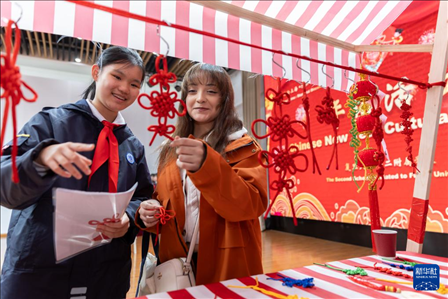 1月28日，復(fù)旦大學(xué)第二附屬學(xué)校學(xué)生（左）為美國馬斯卡廷中學(xué)學(xué)生（右）介紹中國結(jié)。 新華社記者 王翔 攝