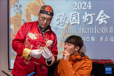 1月28日，在上海豫園舉行的民俗活動上，美國馬斯卡廷中學(xué)學(xué)生在非遺傳承人的指導(dǎo)下吹糖偶。 新華社記者 王翔 攝