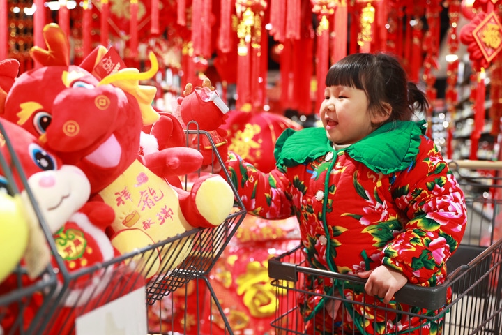 1月23日，在貴州省黔東南苗族侗族自治州岑鞏縣一家超市，小朋友在家人的帶領(lǐng)下選購龍年毛絨玩具。新華社發(fā)（唐鵬攝）