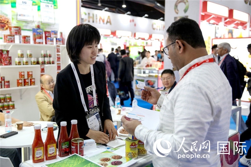 圖為中國(guó)參展企業(yè)代表與采購商交流。人民網(wǎng) 塔里克·易卜拉欣攝