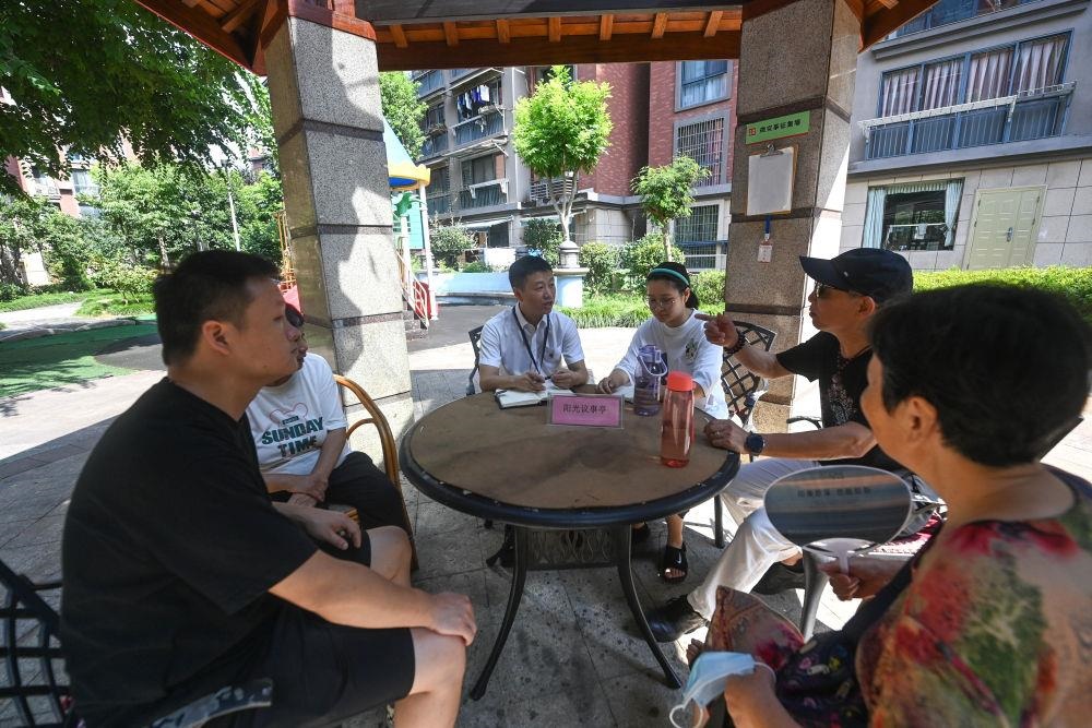 △2023年7月21日，在位于浙江杭州臨安區(qū)錦南街道水岸陽光小區(qū)的陽光議事廳，街道干部在聽取居民們反映的問題及意見。