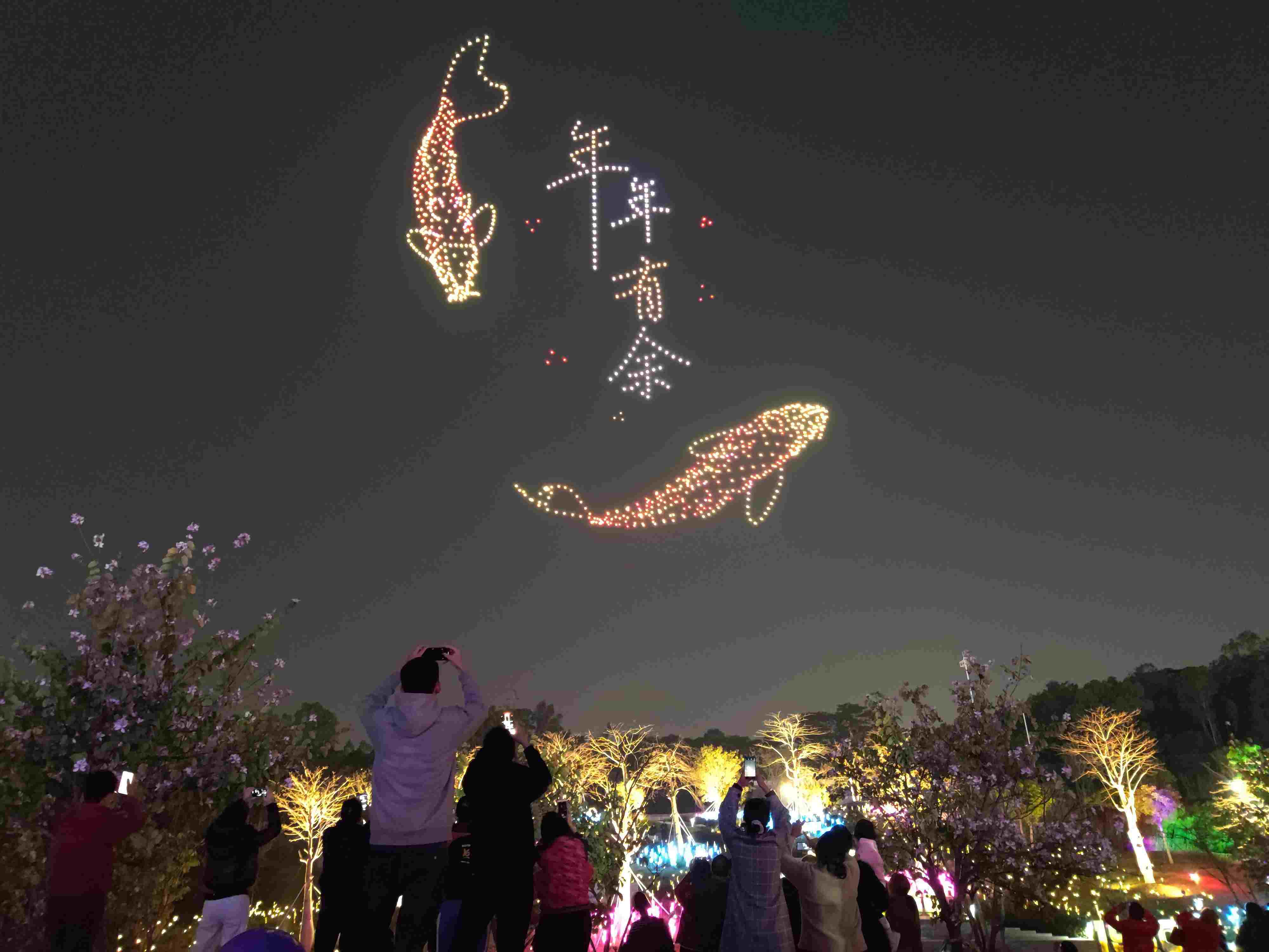 △ 2024年2月10日，深圳北站中心公園，春節(jié)主題無(wú)人機(jī)燈光秀引來(lái)眾多游客駐足觀看。