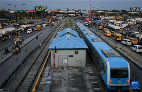 3月4日，在尼日利亞拉各斯，一列輕軌藍線列車行駛至公路交通擁堵路段附近。新華社記者 韓旭 攝