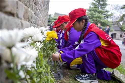 在山東棗莊臺兒莊古城，當(dāng)?shù)貙W(xué)生參加鮮花祭奠活動。（受訪單位供圖）