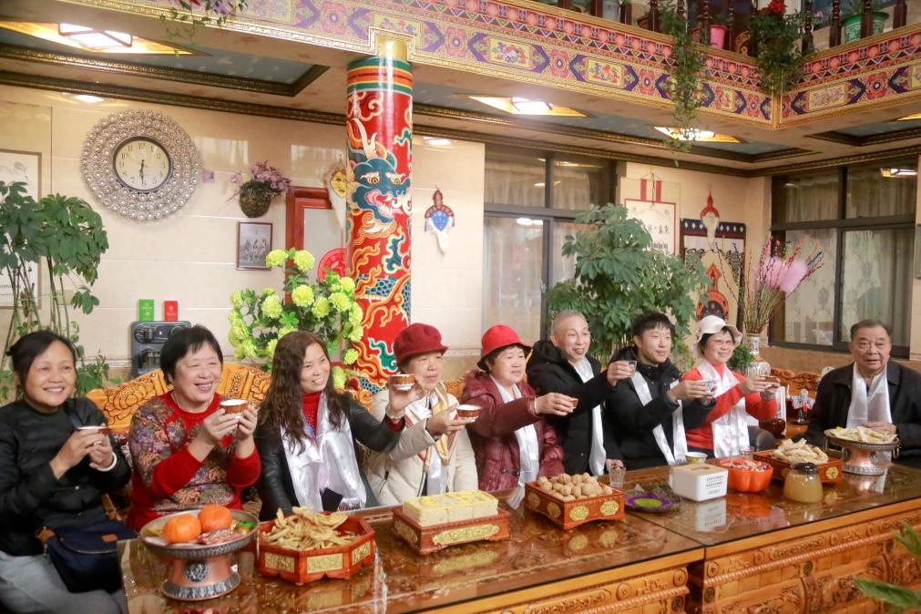 游客們?nèi)胱∶袼藓?，舉杯共飲酥油茶。新華社記者 邱星翔 攝