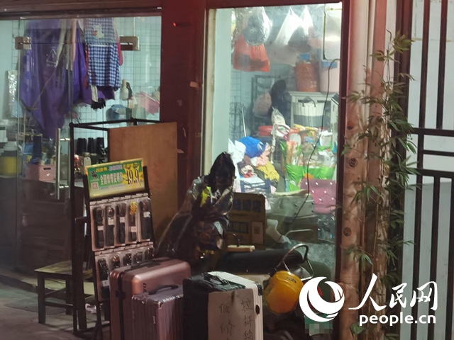 南寧“城中村”一裁縫鋪老板將電線從店內(nèi)拉出為電動自行車充電。人民網(wǎng) 覃心攝
