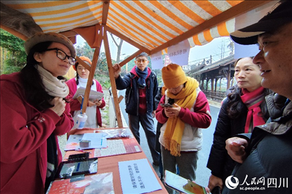 1月6日，“2024成都蒲江柑甜采摘節(jié)”上，記者見到了小萌（左一）和許多年輕人忙著做訪客接待、現(xiàn)場布置、票務(wù)核對、采摘服務(wù)等工作。人民網(wǎng)記者朱虹攝