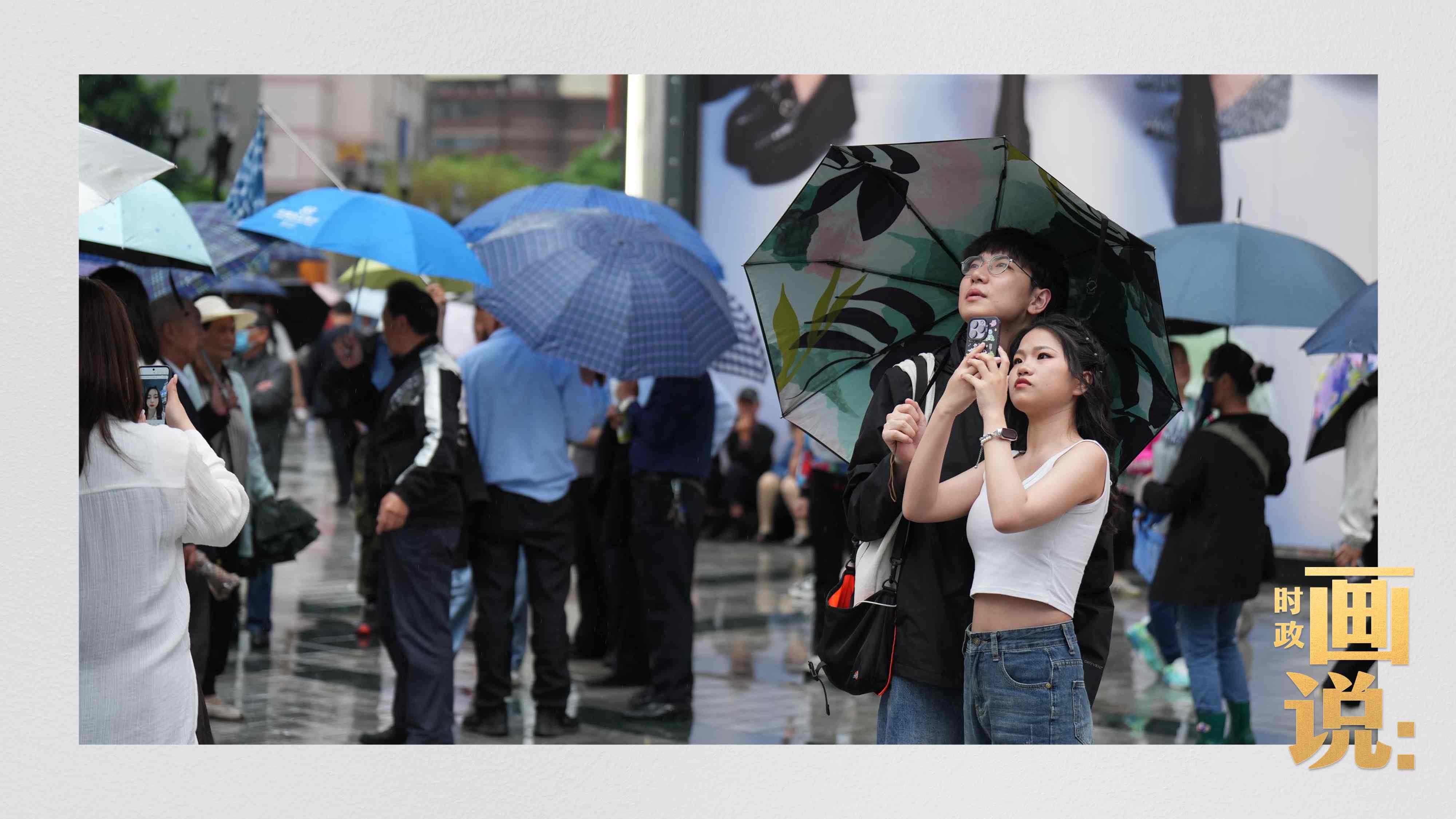 △細雨中的解放碑步行街，騎在父親肩膀的小女孩好奇張望。