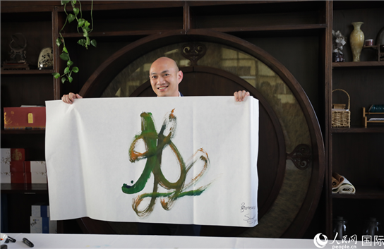 老撾駐華大使館三秘明君參加《五百筆·瀾湄合作》集體藝術(shù)創(chuàng)作。人民網(wǎng)王婧攝。