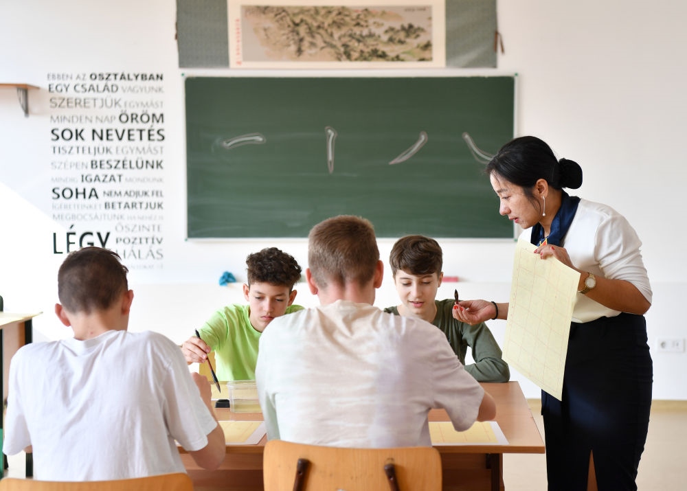 2023年2月24日，在匈牙利首都布達佩斯的匈中雙語學校，中國教師指導學生們學習書法。新華社記者 連漪 攝