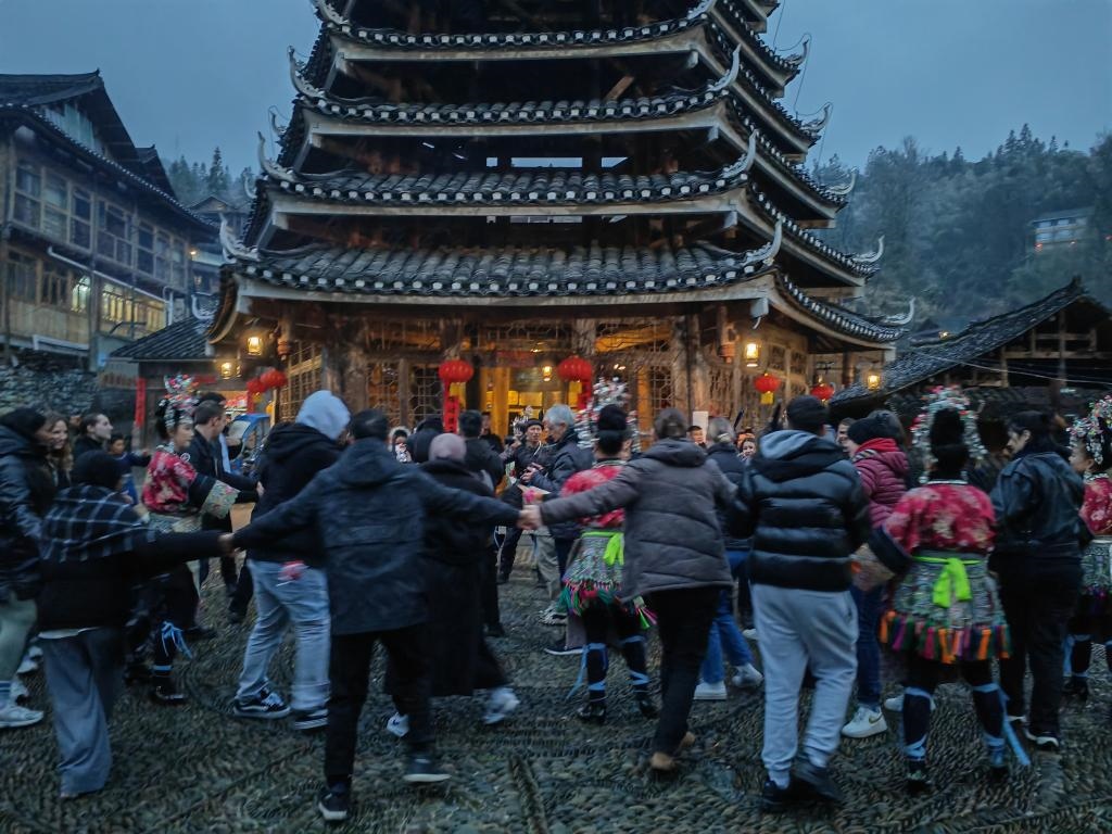 法國青年與當(dāng)?shù)卮迕駹渴痔?。新華社記者 羅羽 攝