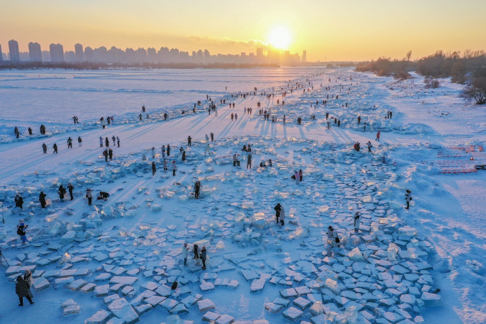 2024年1月7日，在封凍的松花江哈爾濱段，游客在日落時分的“鉆石?！庇瓮妫o人機照片）。新華社記者 謝劍飛 攝