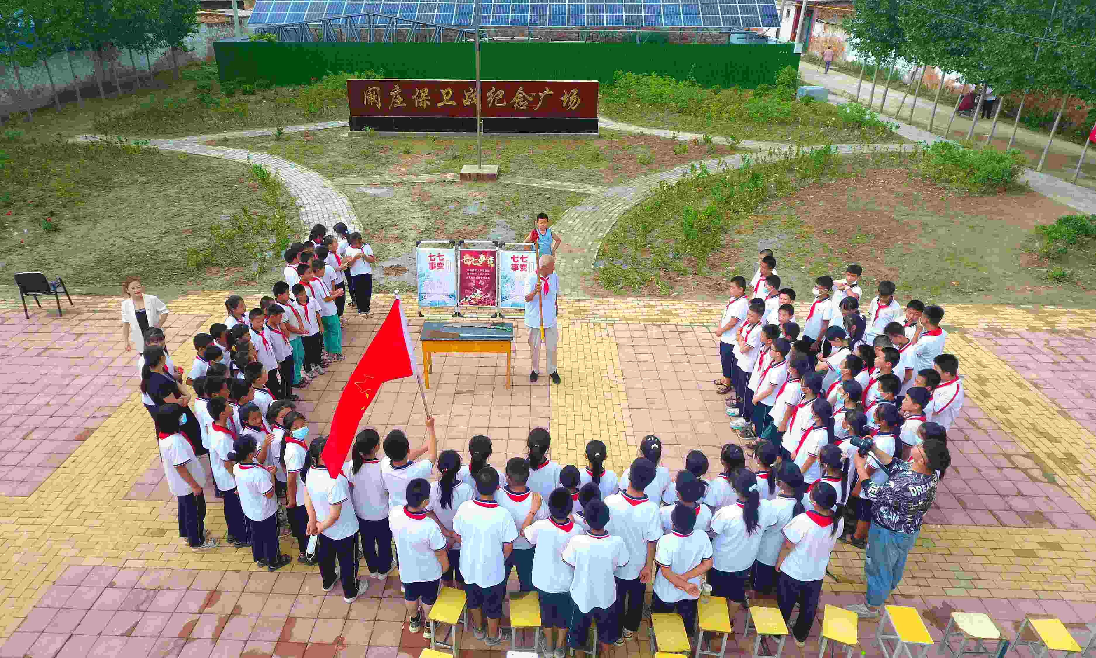 2022年7月6日，山東省聊城市，在茌平區(qū)菜屯鎮(zhèn)闞莊村的闞莊保衛(wèi)戰(zhàn)紀(jì)念廣場，闞莊保衛(wèi)戰(zhàn)親歷者王光木老人為小學(xué)生們講述抗戰(zhàn)故事，展示大刀、長矛。