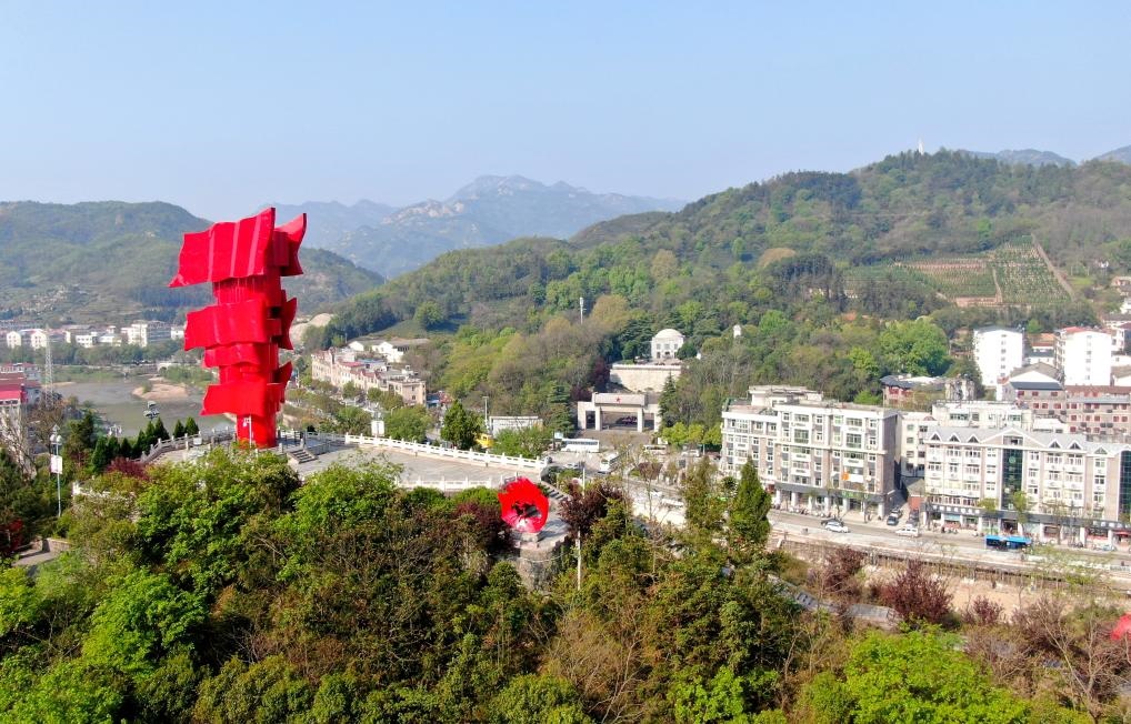 這是2021年4月9日拍攝的鄂豫皖蘇區(qū)首府革命博物館附近的英雄山上的“紅旗飄飄”主題雕塑（無人機照片）。新華社發(fā)