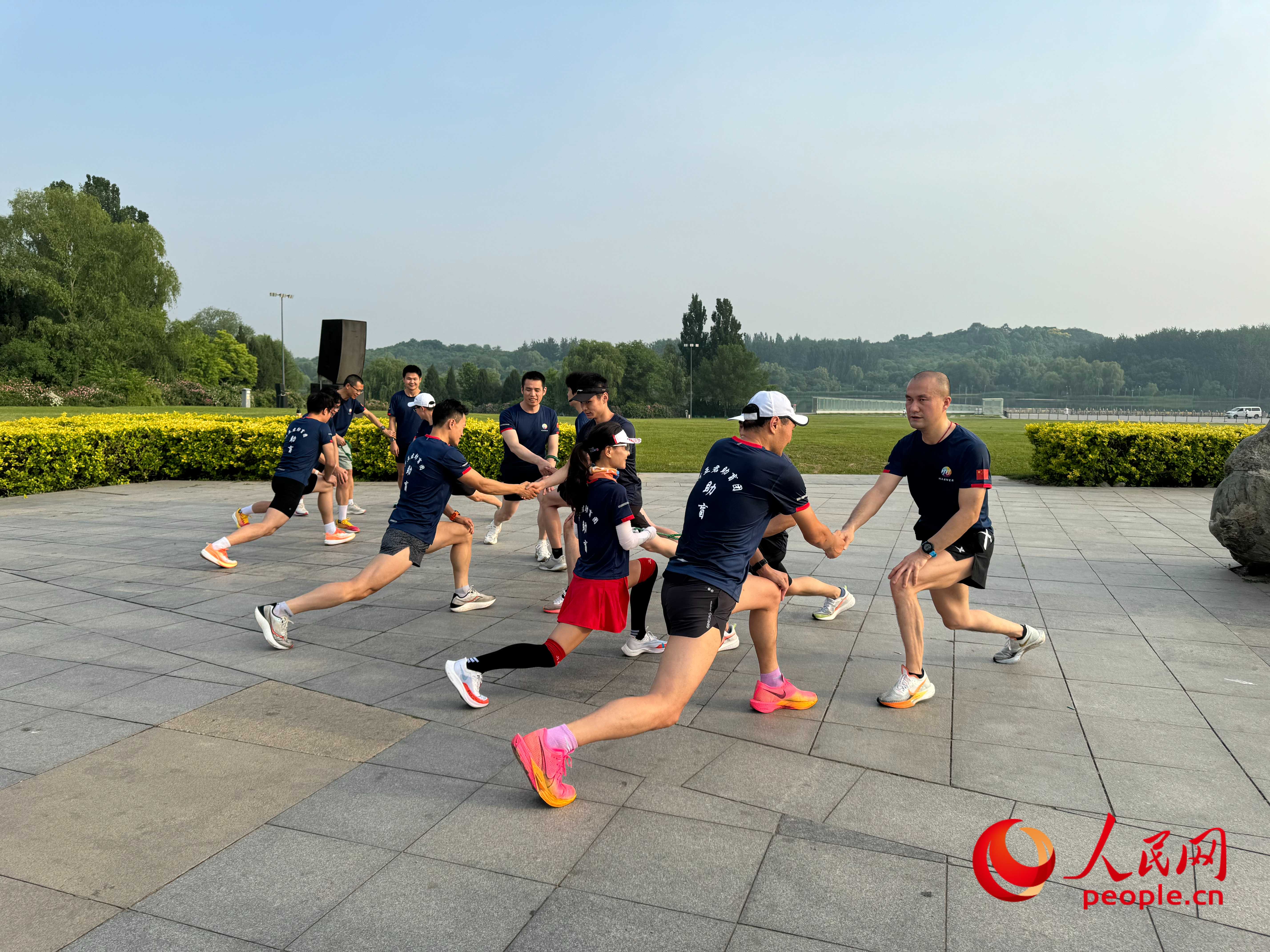 盲人和志愿者做跑步前準(zhǔn)備。人民網(wǎng) 周靜圓攝