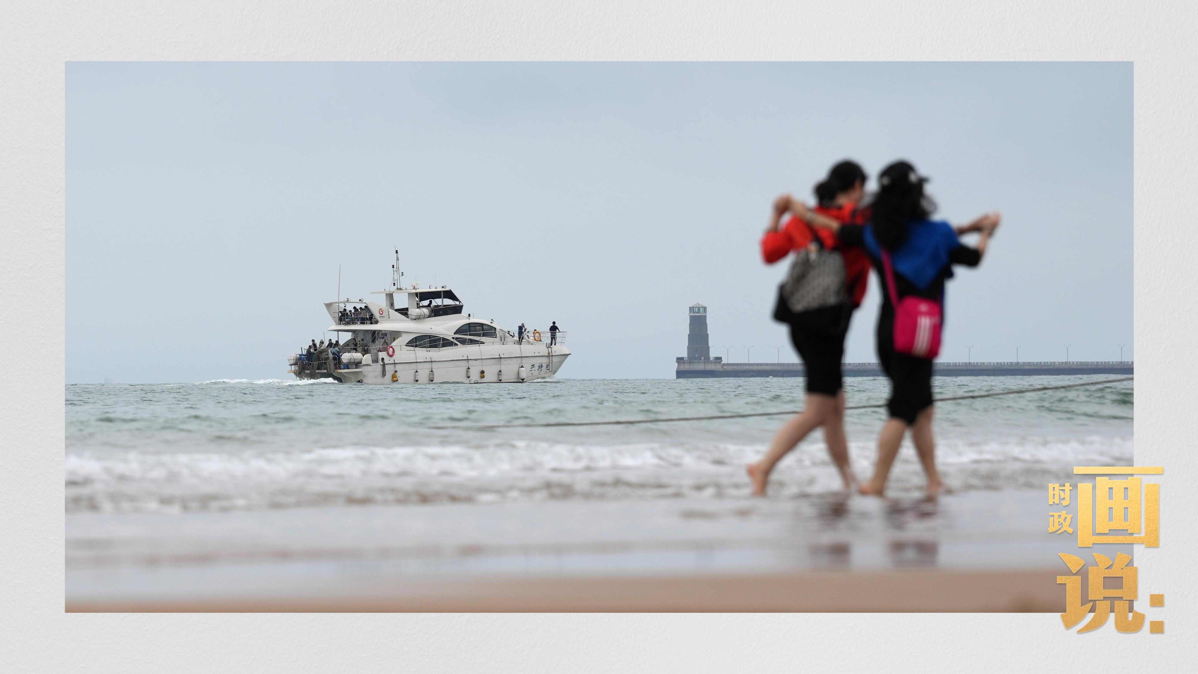 △日照陽光海岸綠道上的萬平口景區(qū)，一對游客在海浪中翩然起舞。