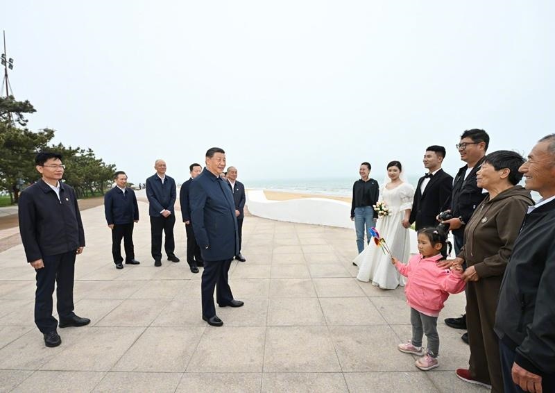 5月22日，在山東日照考察調(diào)研的習近平總書記來到陽光海岸綠道，同市民游客親切交流。