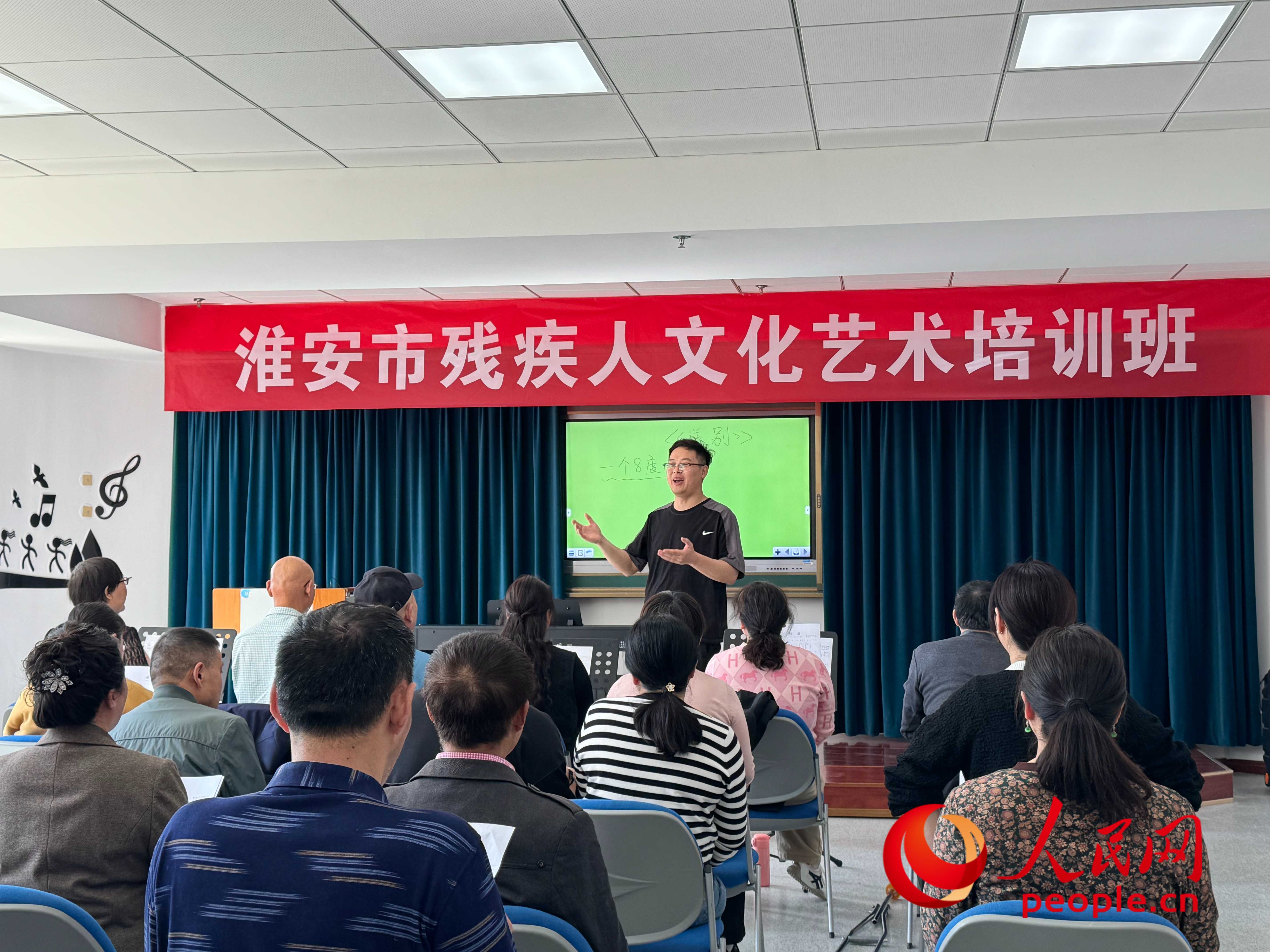 在淮安市殘疾人文化藝術(shù)培訓(xùn)班上，聲樂老師在教殘疾人唱《送別》這首歌曲。人民網(wǎng) 周靜圓攝