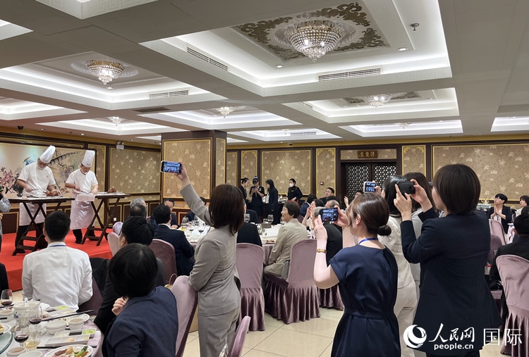國家級非物質(zhì)文化遺產(chǎn)、全聚德片鴨工藝吸引代表團(tuán)成員拍照留念。