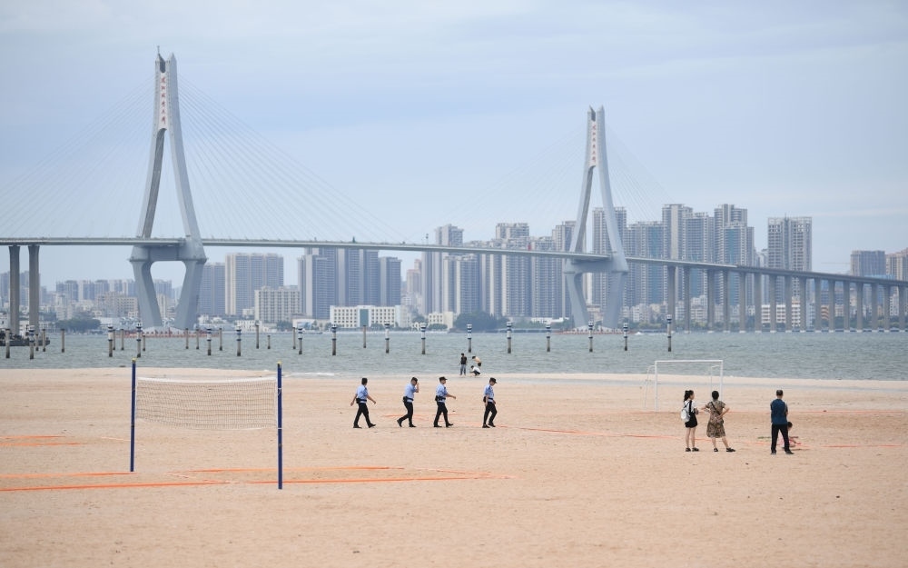 2023年7月17日，廣東湛江五環(huán)廣場(chǎng)的沙灘上，公安民警在執(zhí)勤巡邏。新華社記者 鄧華 攝