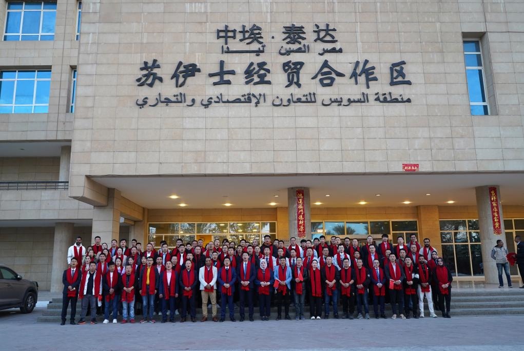 2024年2月11日，在位于埃及蘇伊士省的中?！ぬ┻_(dá)蘇伊士經(jīng)貿(mào)合作區(qū)，中埃員工在合作區(qū)辦公大樓前合影拜年。新華社發(fā)（泰達(dá)合作區(qū)供圖）