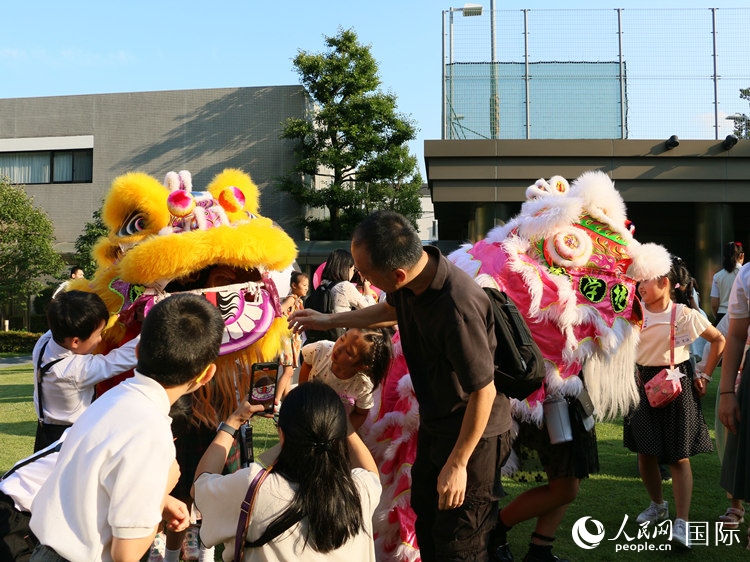 孩子們好奇地圍觀舞獅。人民網(wǎng) 許可攝