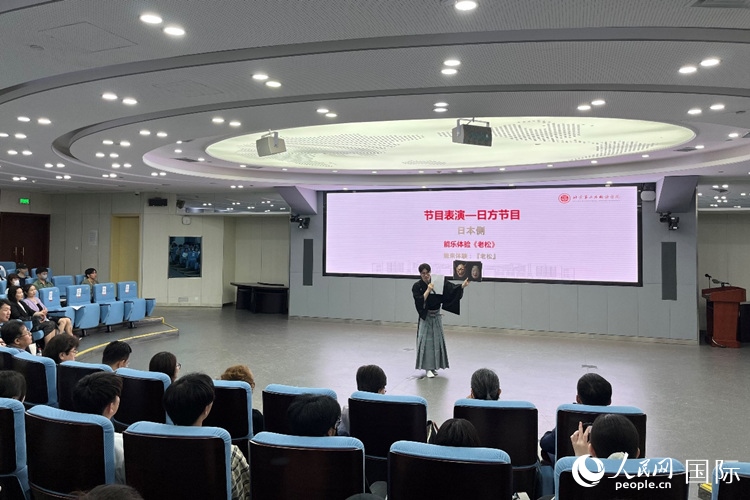 日本大學(xué)生介紹能樂知識。人民網(wǎng)記者 陳思攝