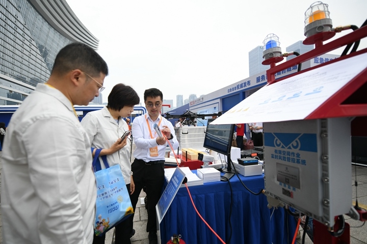 6月16日，在全國“安全宣傳咨詢?nèi)铡敝鲌龌顒由?，四川省安全科學(xué)技術(shù)研究院工作人員（右一）向參觀者介紹“有限空間作業(yè)實時風(fēng)險管控系統(tǒng)”。新華社記者胥冰潔攝