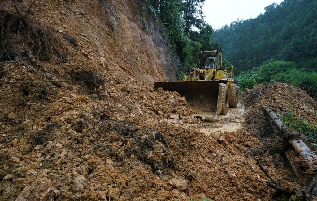 6月18日，在廣西融水苗族自治縣融水鎮(zhèn)新安村，一臺推土機在清理塌方路段。新華社發(fā)（龍林智攝）