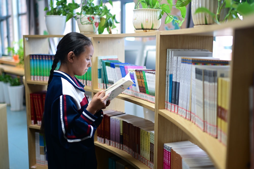 6月18日，果洛西寧民族中學學生尼東拉毛在圖書室看書。