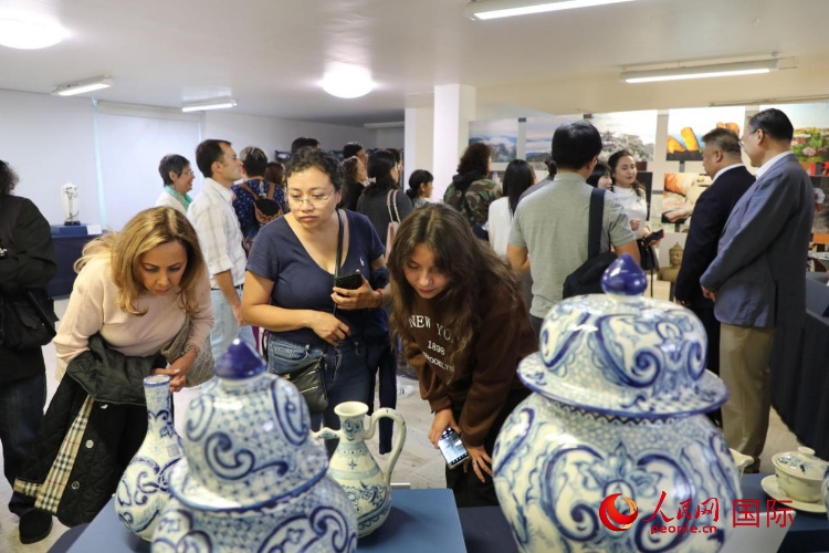 在展覽現(xiàn)場(chǎng)，觀眾們駐足欣賞德化瓷和墨西哥彩瓷。人民網(wǎng) 埃內(nèi)斯托·多明戈斯攝