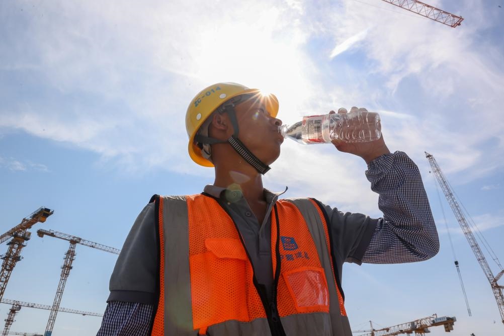 6月18日，在江蘇省無錫市奧體三期項(xiàng)目施工現(xiàn)場，中建二局工人在喝水解暑。新華社發(fā)（朱吉鵬 攝）