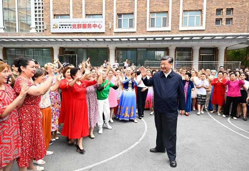 2022年7月13日，習(xí)近平總書記在新疆烏魯木齊市天山區(qū)固原巷社區(qū)考察時，向各族群眾揮手致意。