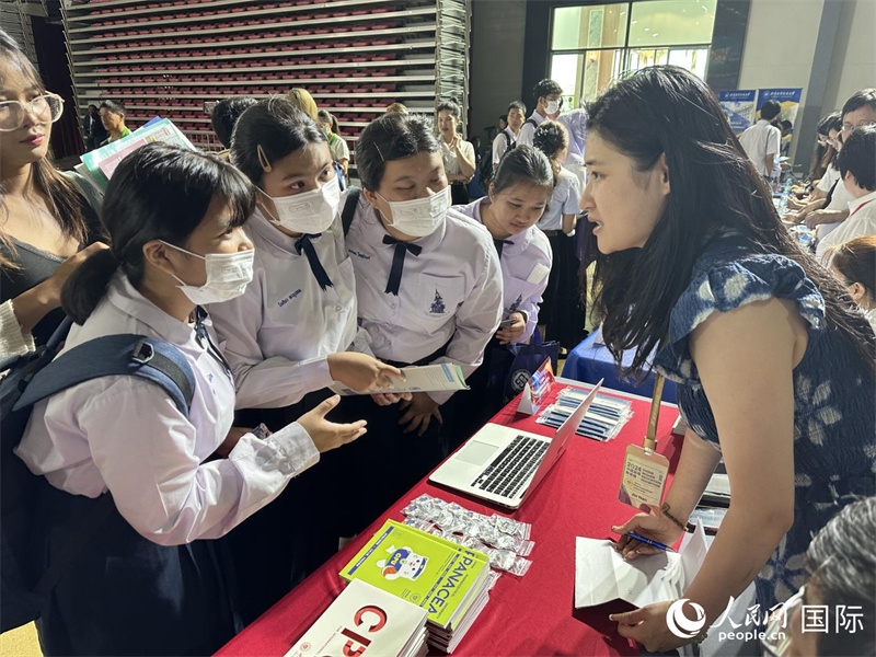 來自泰國的學(xué)生、家長在教育展臺前咨詢。人民網(wǎng)記者 簡承淵攝