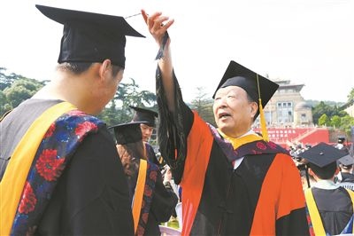 2017年6月22日，李德仁（右一）參加武漢大學(xué)畢業(yè)典禮并為畢業(yè)生撥穗。