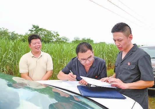 圖③：清塘后，執(zhí)行干警與某農(nóng)場負責人確認魚塘交付情況。