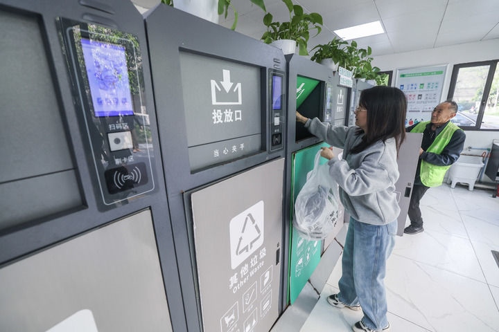 2024年4月10日，在浙江省湖州市吳興區(qū)飛英街道新華府小區(qū)內(nèi)，居民在垃圾分類智能系統(tǒng)的指導(dǎo)下進行垃圾分類投放，居民的投放情況將實時匯總到智慧服務(wù)平臺，會有相應(yīng)的積分獎勵。新華社記者 徐昱 攝