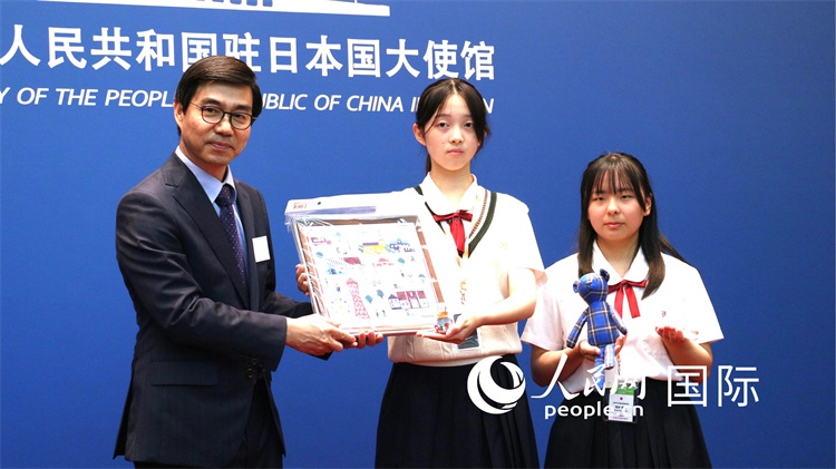日本小大使向中國駐日本大使館臨時代辦施泳贈送當?shù)靥厣Y品。人民網(wǎng) 許可攝