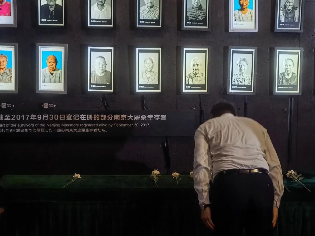7月18日，人們向離世的南京大屠殺幸存者獻花、鞠躬。新華社記者邱冰清 攝