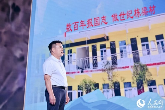 張玉滾分享用一根扁擔(dān)送孩子們走出大山的故事。人民網(wǎng)攝