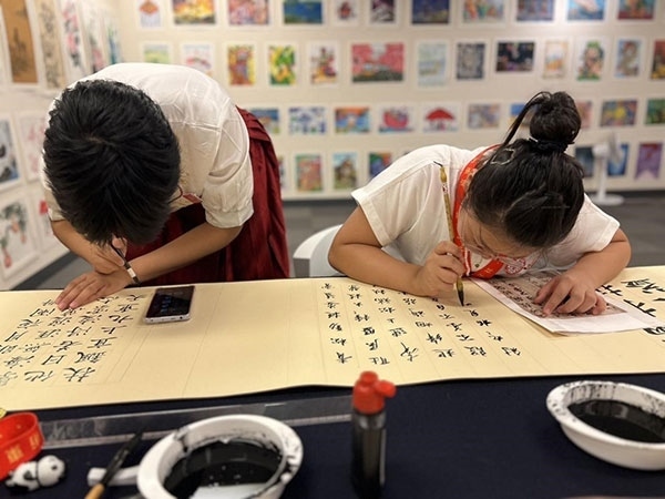 參加本次展覽的青少年在現(xiàn)場進行書法創(chuàng)作。主辦方供圖