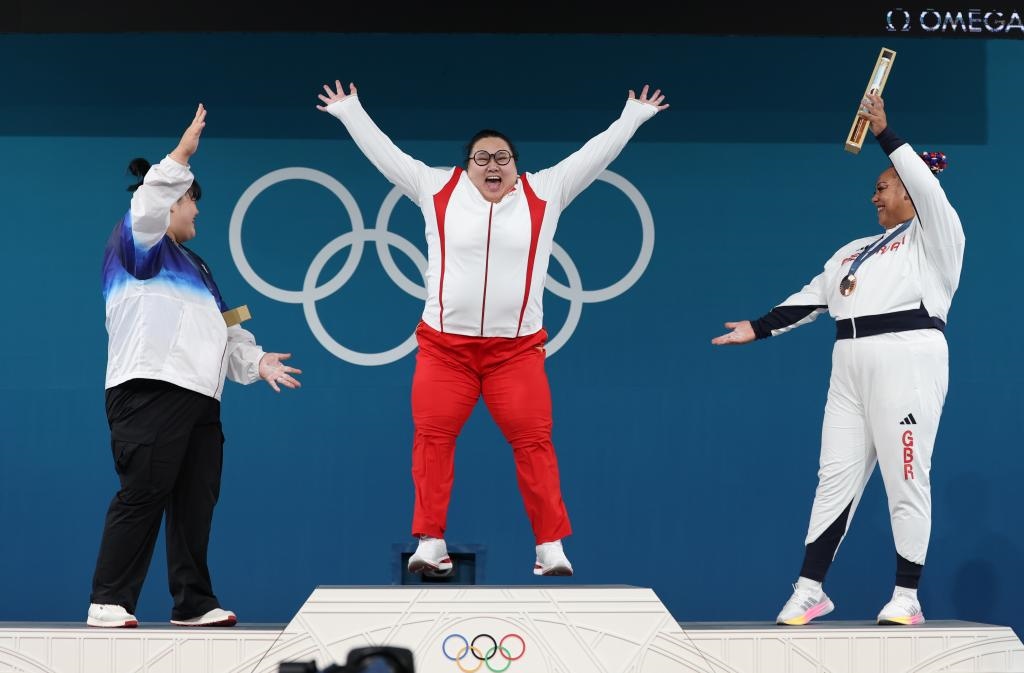 中國(guó)選手李雯雯（中）在巴黎奧運(yùn)會(huì)舉重女子81公斤以上級(jí)頒獎(jiǎng)儀式中登上領(lǐng)獎(jiǎng)臺(tái)（2024年8月11日攝）。新華社記者 楊磊 攝