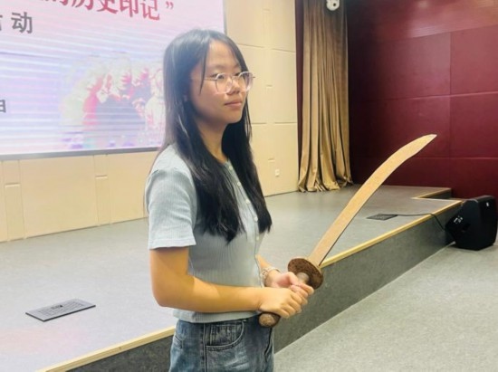 圖為南開大學(xué)社會(huì)實(shí)踐隊(duì)學(xué)生代表呼月紅在學(xué)術(shù)交流活動(dòng)現(xiàn)場，展示河間調(diào)研行中獲贈(zèng)的一戰(zhàn)華工蔡世春曾使用過的一把大刀。林卓瑋 攝