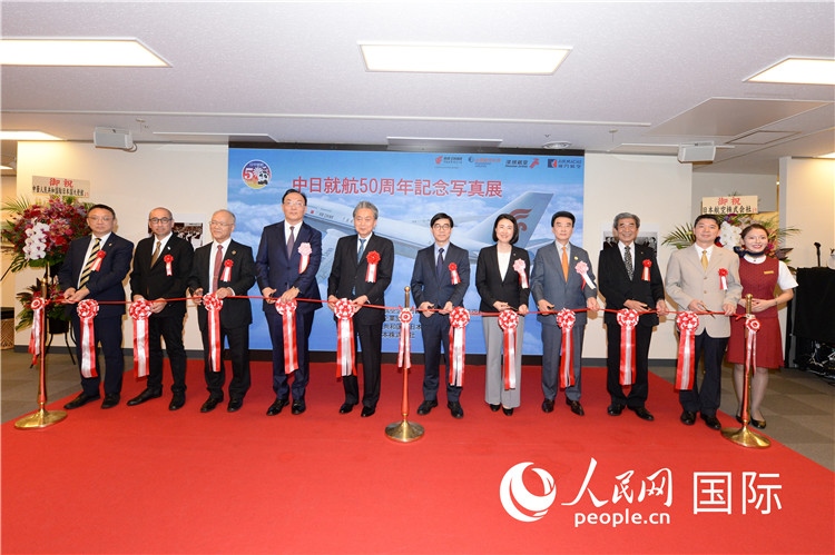 與會嘉賓共同為中日通航50周年紀念圖片展開幕剪彩。馮學(xué)敏攝